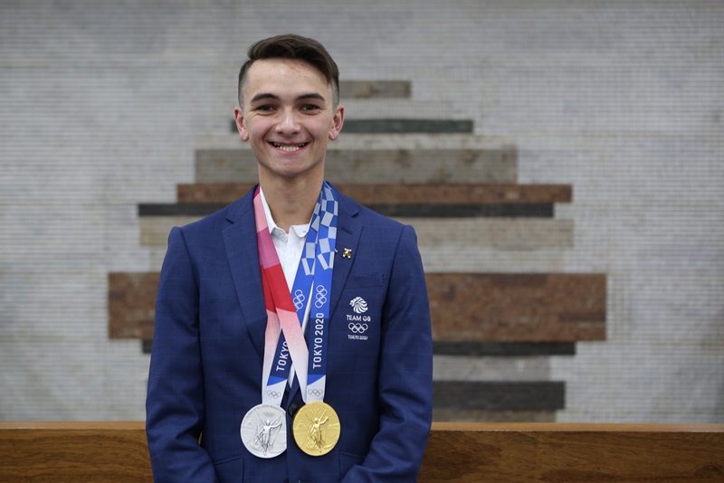 Alex Yee wearing a Gold and Silver medal