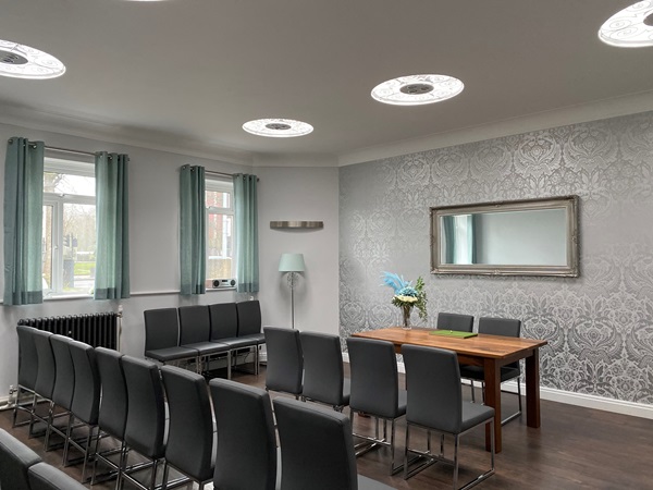 A room with chairs set out for a wedding